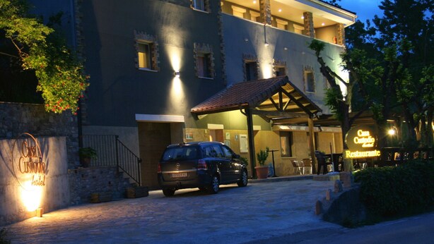 A hotel with a stone facade, a covered entrance, and a parked car. - Hotel Casa Custodio (Isabena)