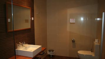 Un baño con lavamanos, espejo e inodoro blancos.