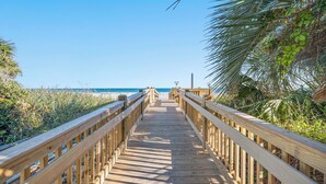 A wooden boardwalk leading to a beach with clear skies. - Carolina Winds by Elliott Beach Rentals (Myrtle Beach)