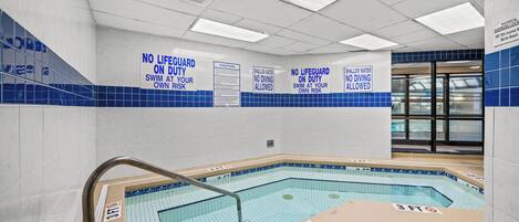 A swimming pool area with safety signs, a 3 FT depth marker, and a tiled wall.