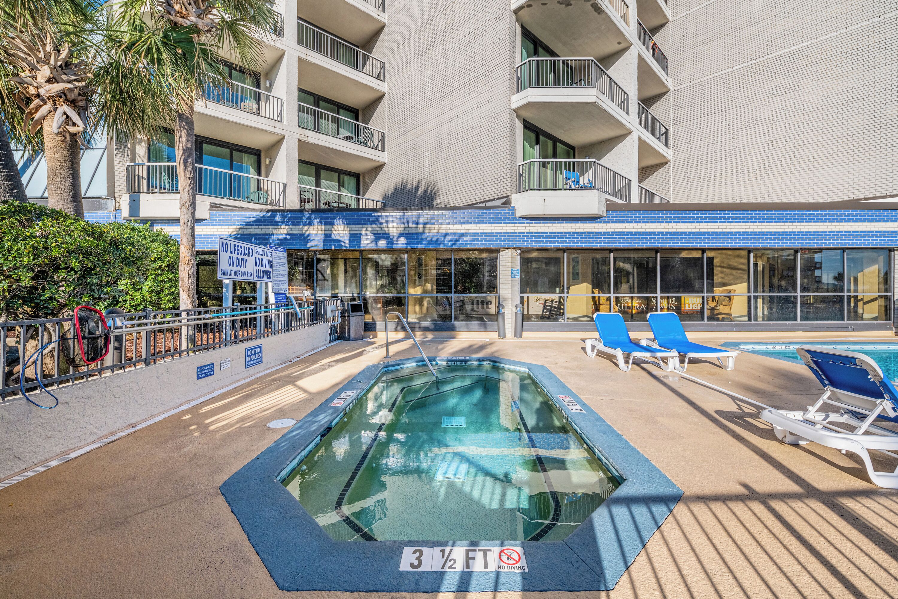 A pool area with a sign indicating a depth of 3 1/2 feet and a no diving warning.