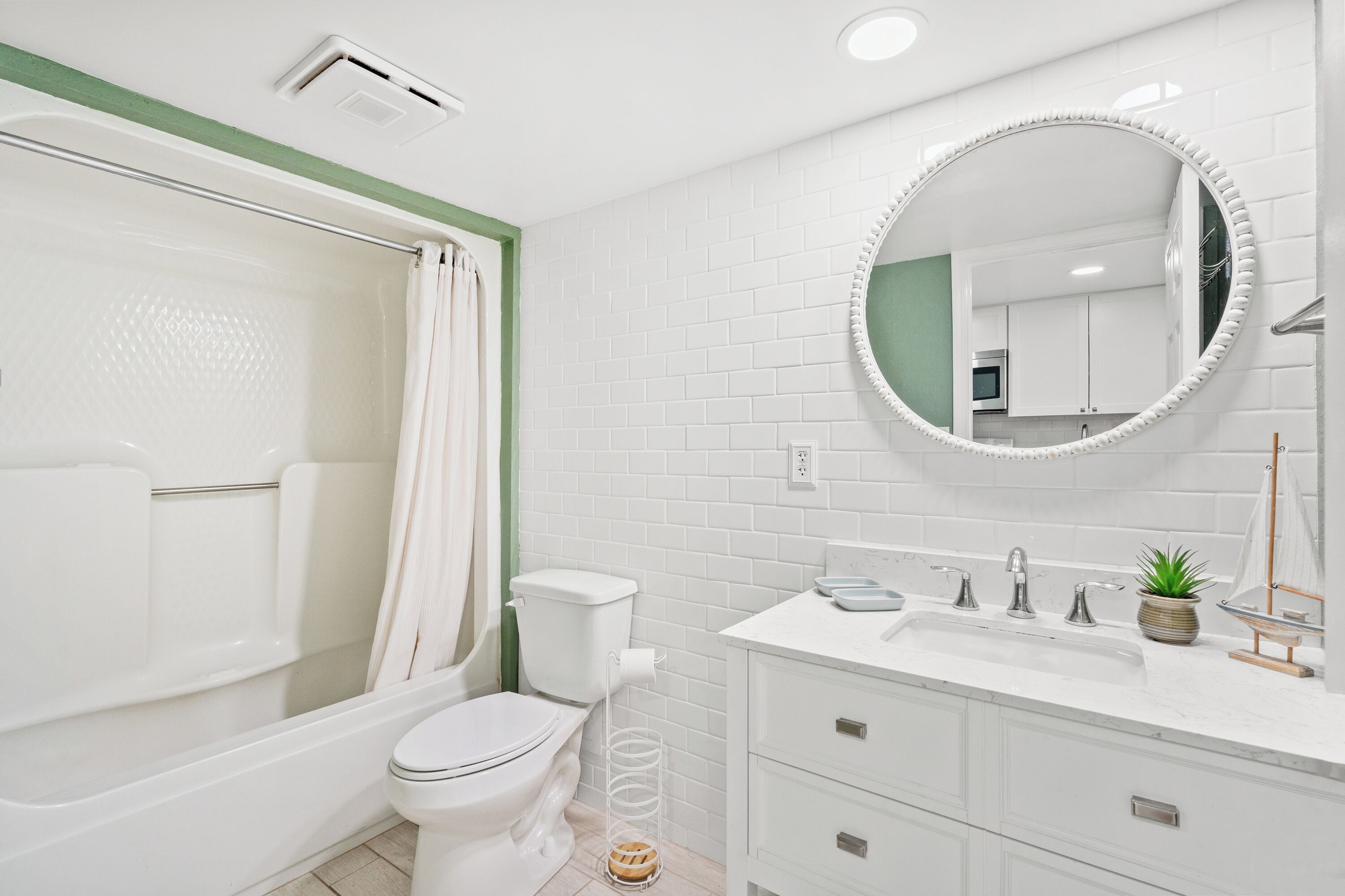 Un bagno moderno con vasca, wc, lavandino e specchio.