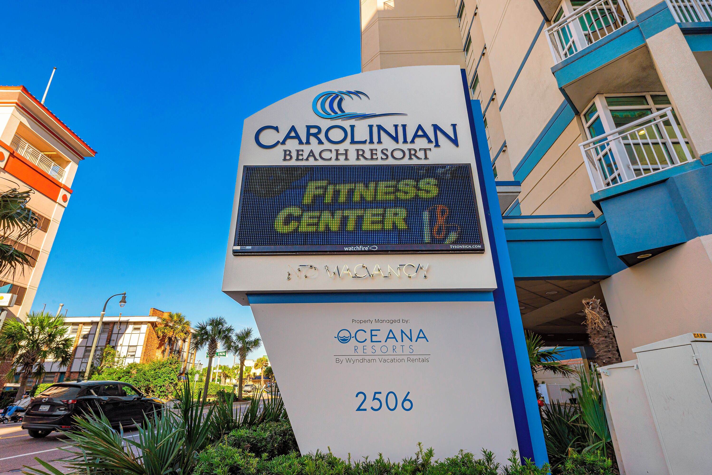 Een bord van Carolinian Beach Resort met een digitaal scherm en een telefoonnummer.