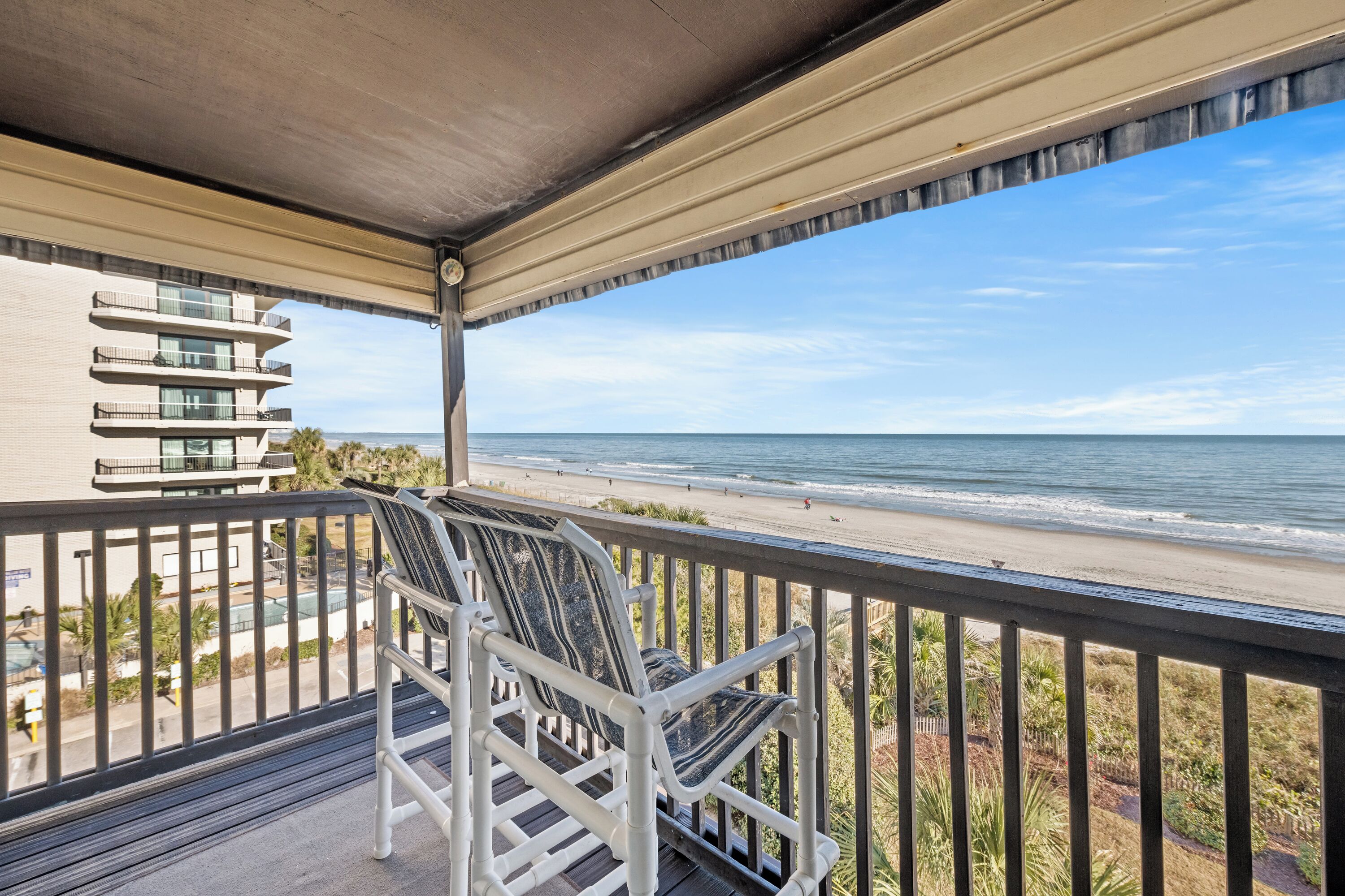 Ein Balkon mit Blick auf Strand und Meer.
