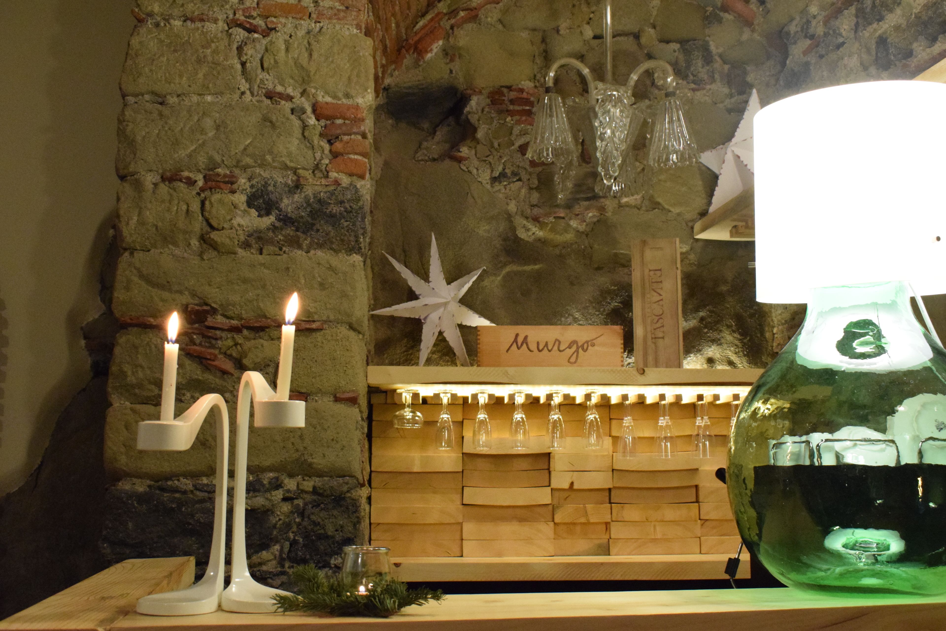 A candlelit display with candles, a star-shaped decoration, and a sign that reads "Murgo".