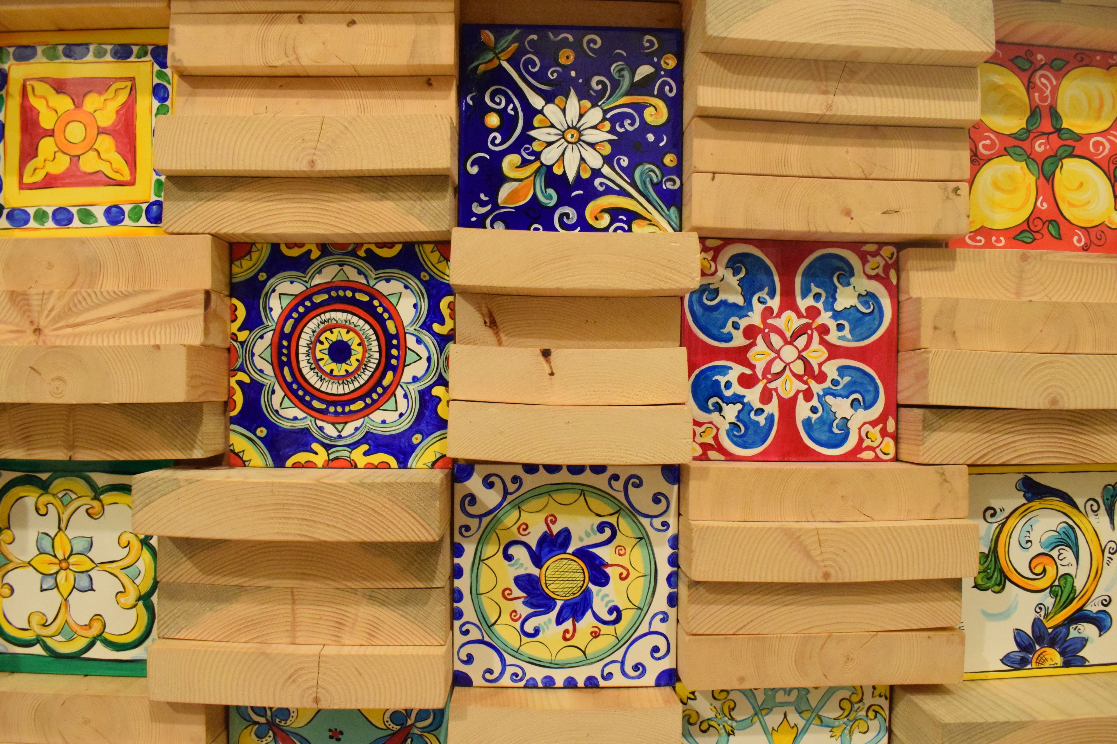 A wall with multiple ceramic tiles, each featuring different patterns and colors.