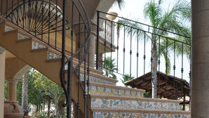 A spiral staircase with ornate railings and colorful tile steps, leading to an upper level. - Tenuta Bellaprima (Niscemi)