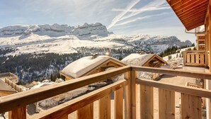 A wooden cabin with a wooden deck overlooking a snowy mountain landscape. - Grand Massif Family Retreat (Arâches-La-Frasse)