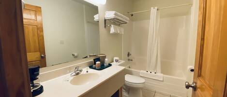 A modern bathroom with a large sink, toilet, and bathtub.