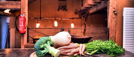 A wooden cutting board with vegetables and a knife on a kitchen counter.