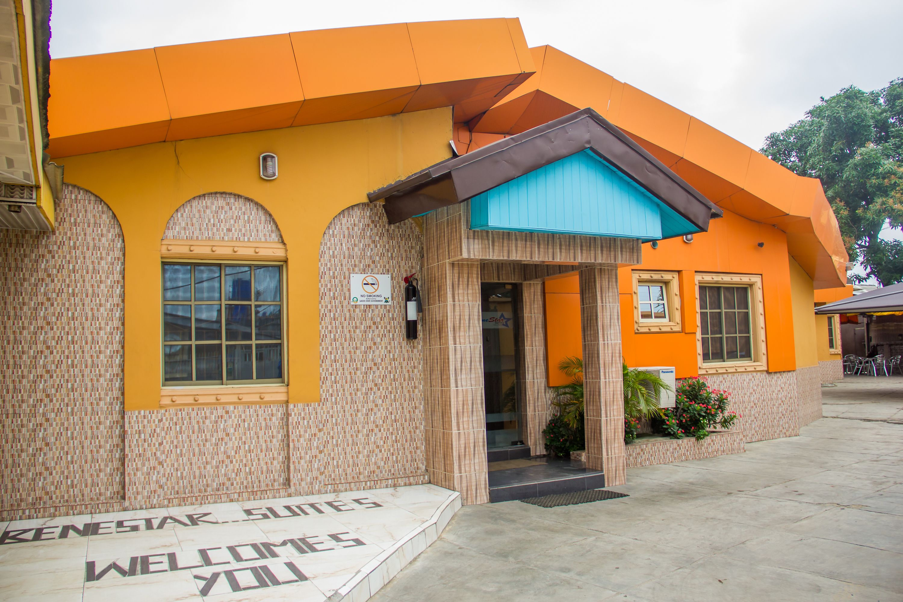 A building with a tiled facade and a sign that reads "Welcome."