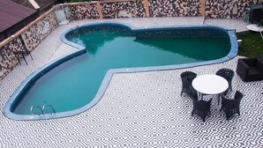 Una piscina con suelo de cuadros y pared de mosaico.