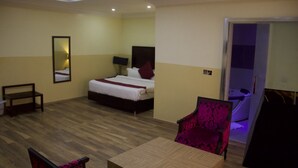 Habitació d'hotel amb llit, cadira, taula i mirall.