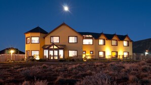 A large, two-story house with a symmetrical facade, multiple windows, and a central entrance. - Hosteria Roble Sur (El Calafate)