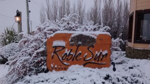 A sign for "Robe Sun" partially covered by snow. - Hosteria Roble Sur (El Calafate)