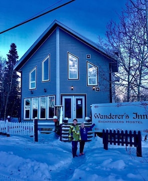Un bâtiment à deux étages avec une enseigne indiquant « Wanderer's Inn Backpackers Hostel ».
