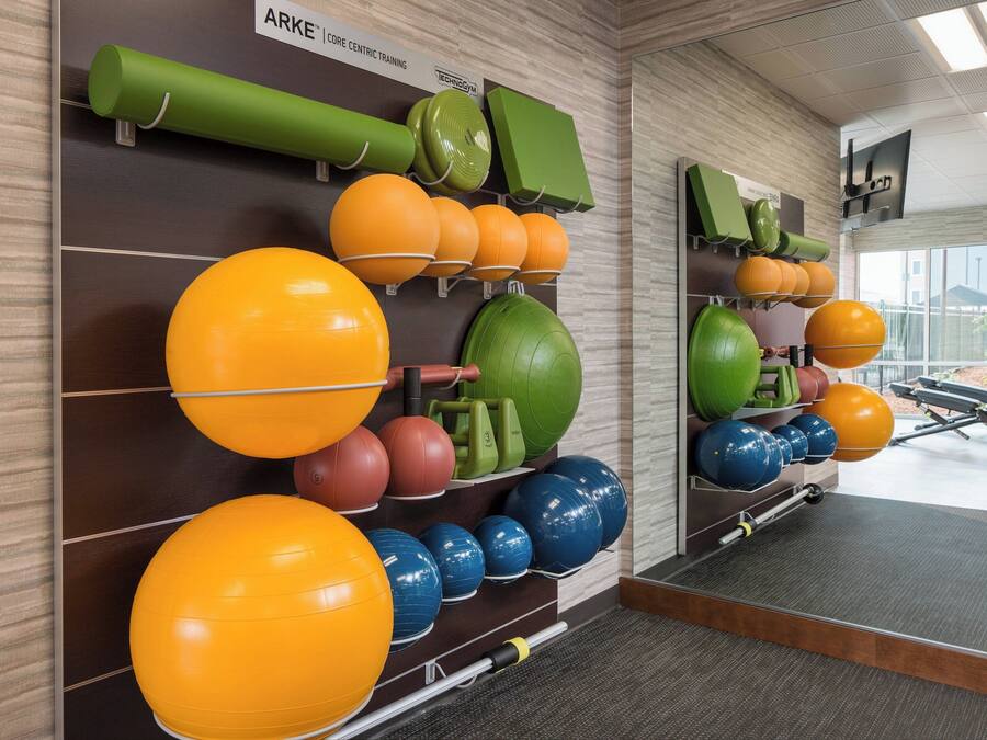 A gym with various exercise balls and equipment.