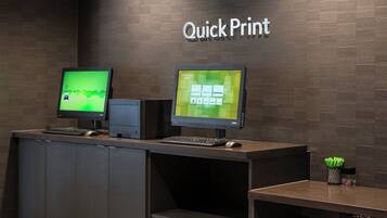 A reception desk with two monitors, a keyboard, and a mouse.