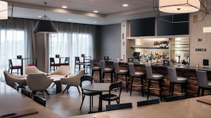 A modern bar area with seating and a bar counter.