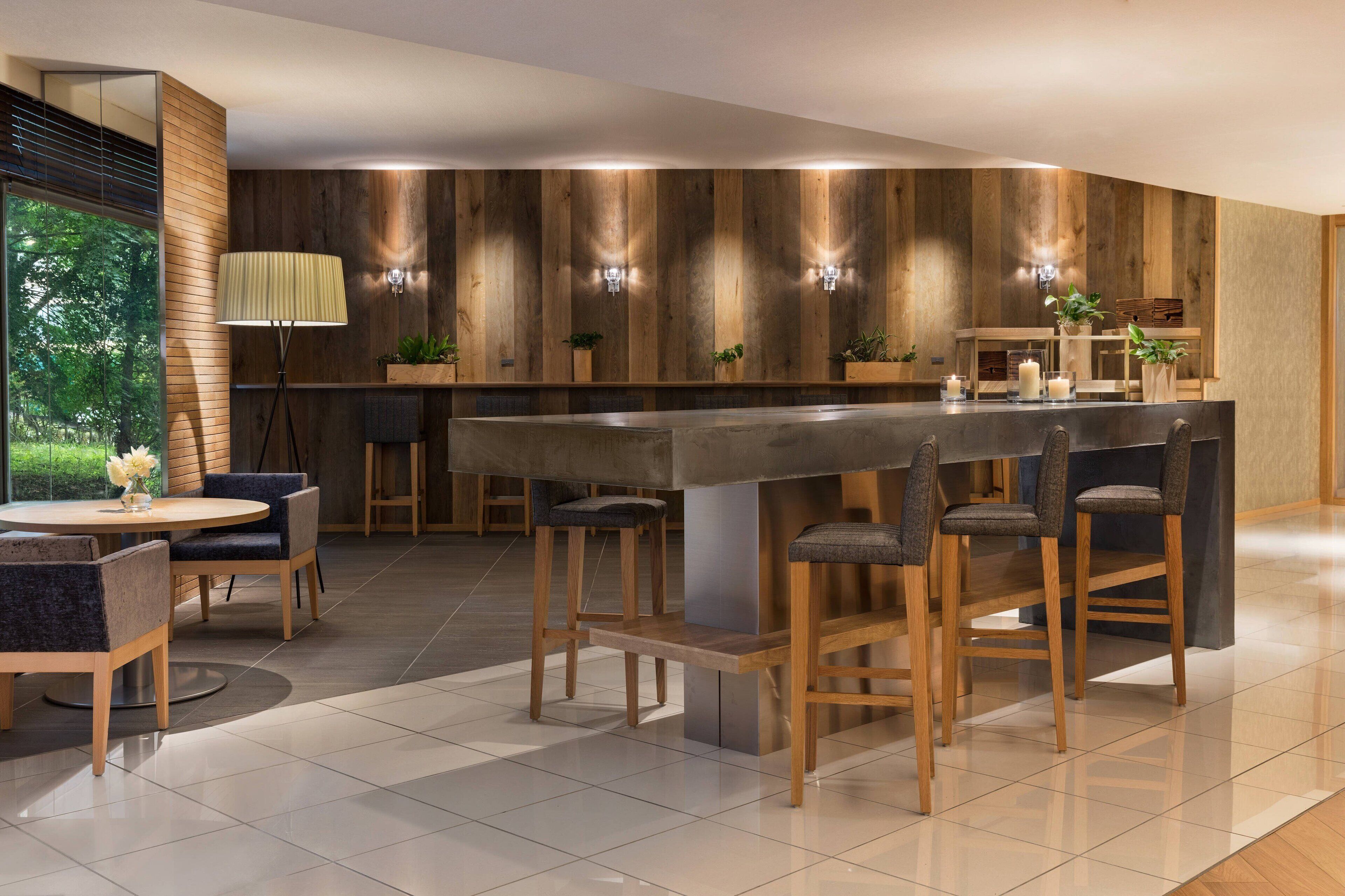 Una cocina moderna con una isla central, taburetes de bar y una zona de comedor con sillas.