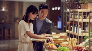 A buffet setup with various food items and a selection of beverages.