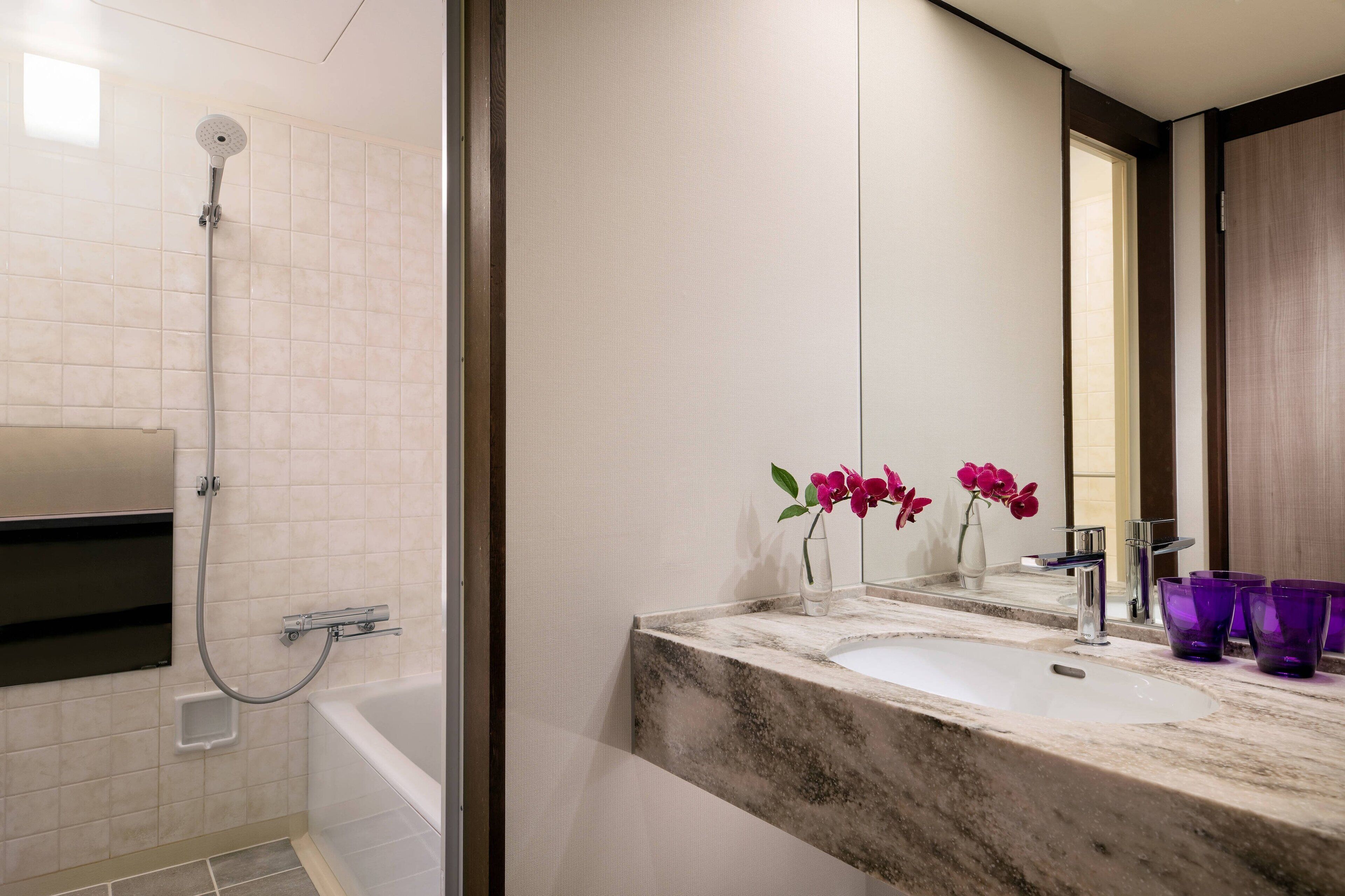 A bathroom with a shower, a sink, and a mirror.