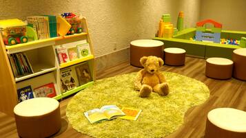 A cozy children's play area with a teddy bear, a book, and a toy car on a round rug.