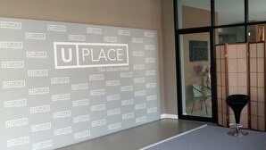 A wall with repeated "UP PLACE" logos and "The Urban Hotel" text.