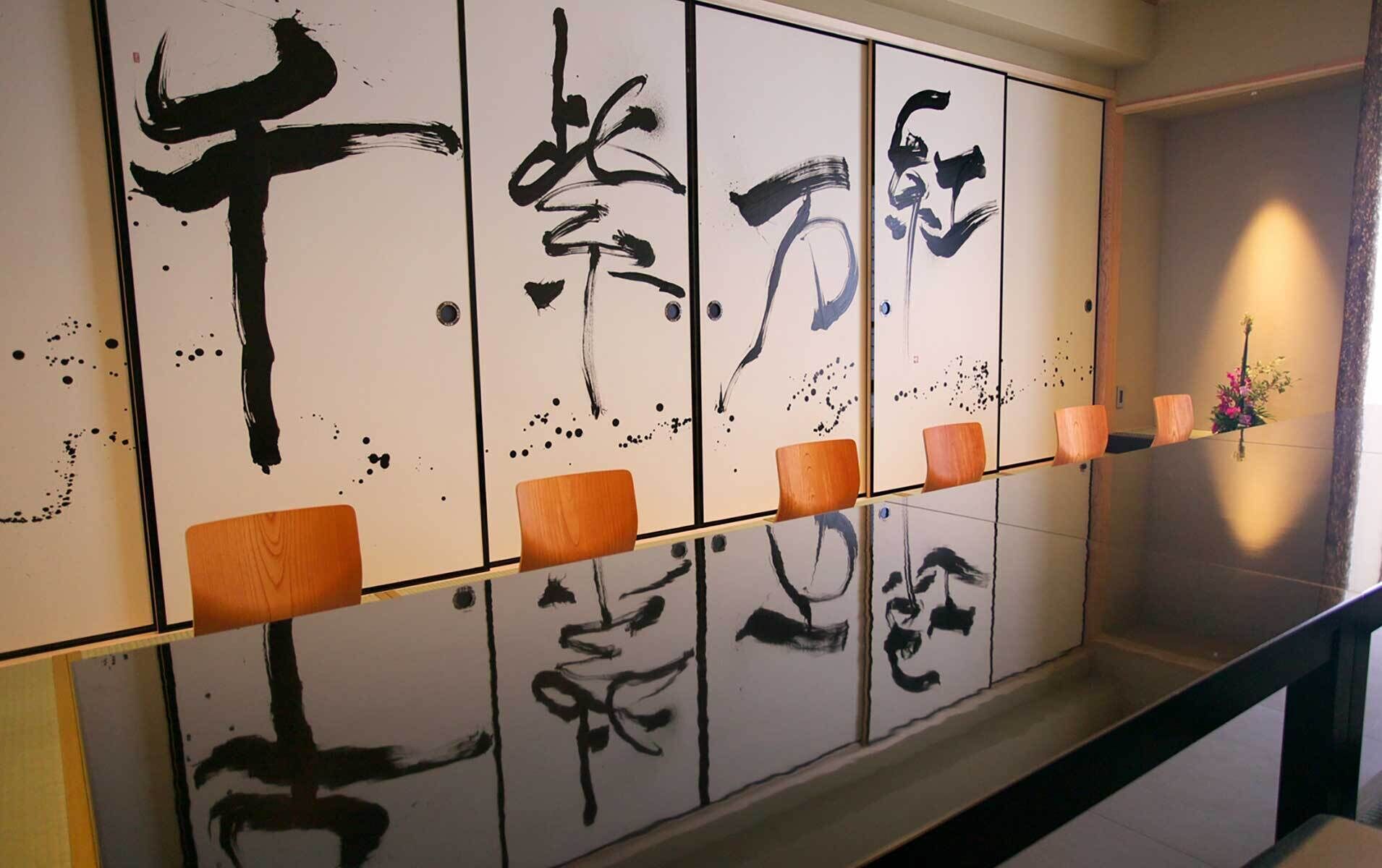 Una habitación con un fusuma tradicional japonés decorado con caligrafía.