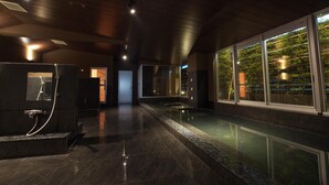 Un área de spa con suelo reflectante, techo de madera y vistas a plantas de interior a través de amplios ventanales.