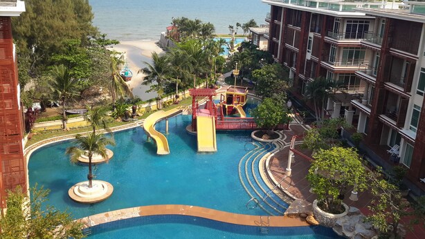 A resort with a swimming pool, a water slide, and a beach view. - Beachfront Family Penthouse Hua Hin (Hua Hin)