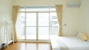 A room with a bed, a window with curtains, an air conditioning unit, and a white shelf. - 3520 B&B (Taitung)