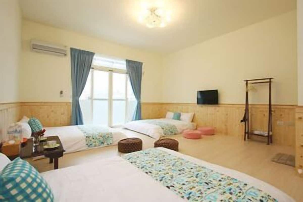 A hotel room with two beds, a television, and a wooden wardrobe.
