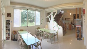 A spacious room with a large window, a staircase, and a kitchen area. - 3520 B&B (Taitung)