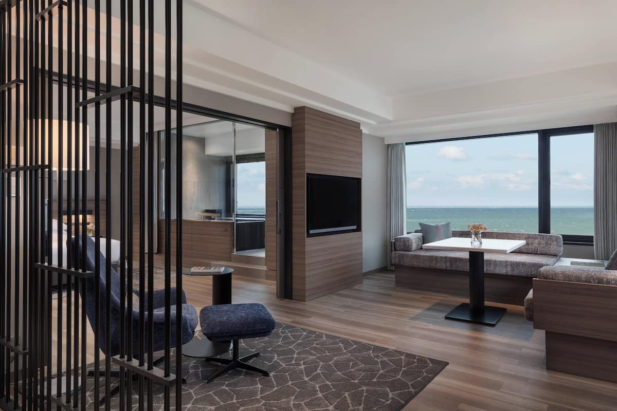 Een moderne woonkamer met een groot raam, een flatscreen televisie en een bank.