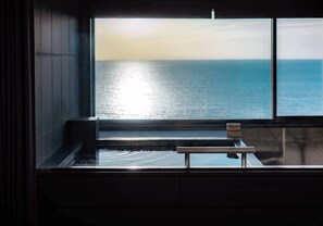 Un bagno con un'ampia finestra vista su un corpo d'acqua.