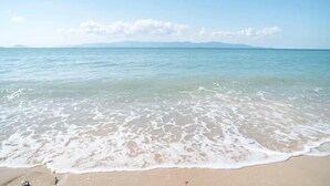 A beach with clear water and a distant mountain range. - Phangan Lodge (Ko Pha-ngan)