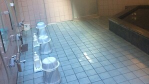 A public restroom with multiple urinals, a hand dryer, and a sink.