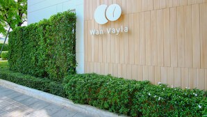 A building with a wooden panel wall and a sign that reads "Wan Vayla". - Hua Hin Luxury Beachfront Condo By Mon (Hua Hin)