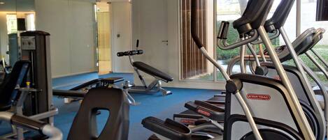 A gym with multiple treadmills, weight machines, and a blue carpeted floor.