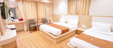 Quarto de hotel com duas camas, uma escrivaninha com cadeira, um espelho e um aparelho de ar condicionado.