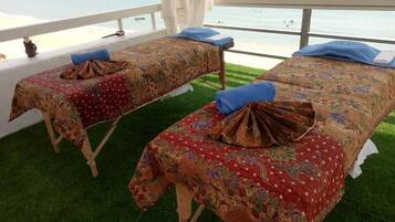 Relax in a serene spa area with two massage tables, a tranquil view, and lush carpeting.