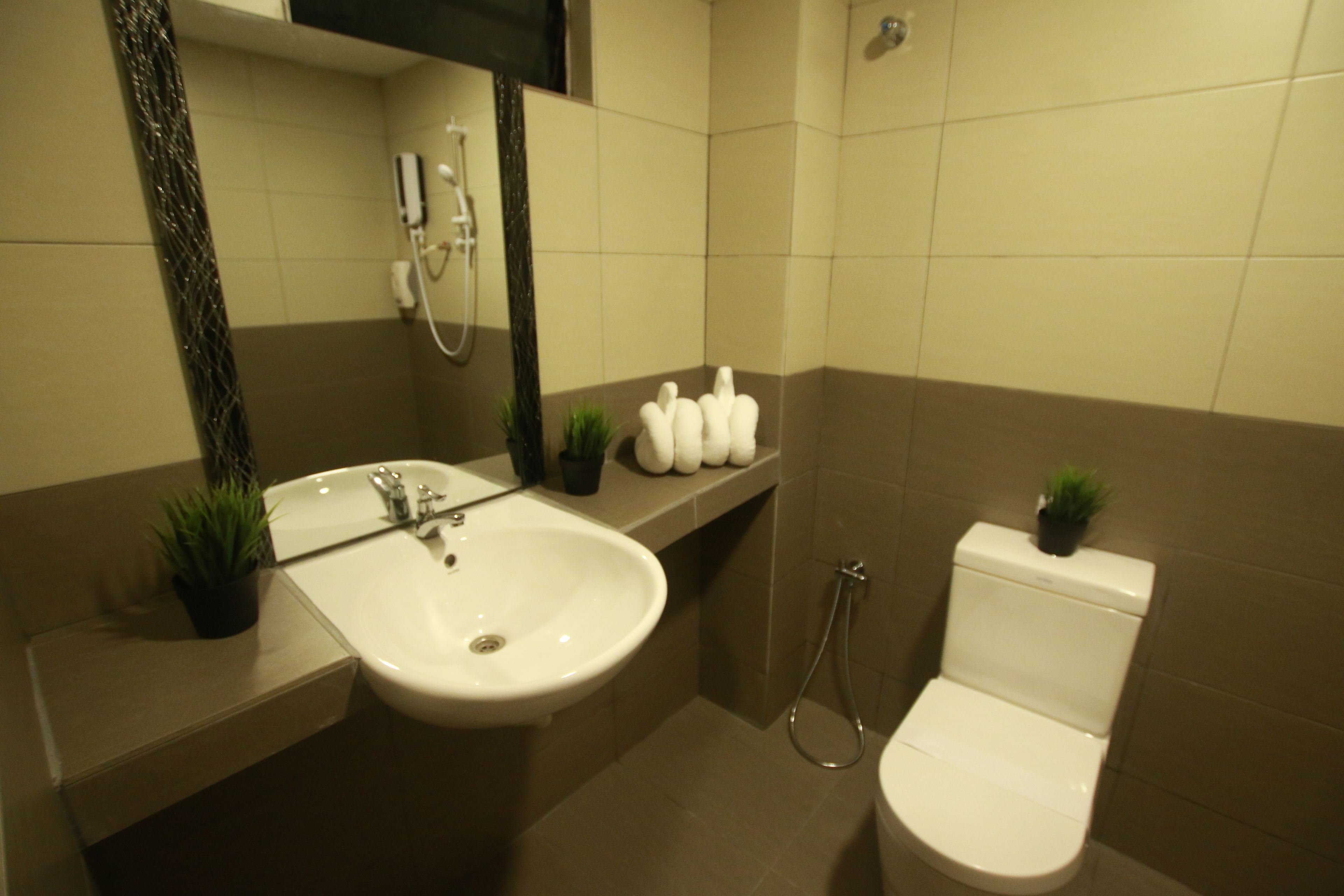 A modern bathroom with a sink, mirror, toilet, and shower.