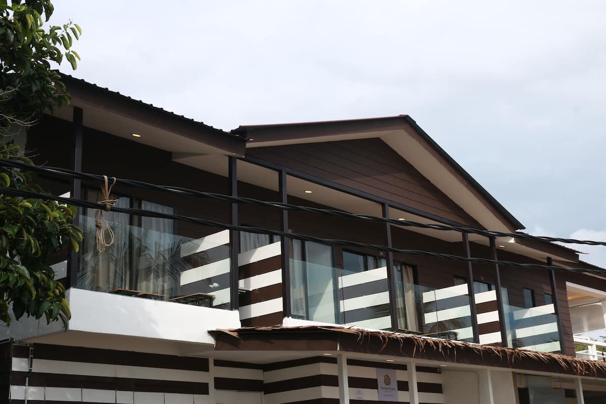 Un edificio moderno con fachada a rayas, ventanas amplias y techo de paja.