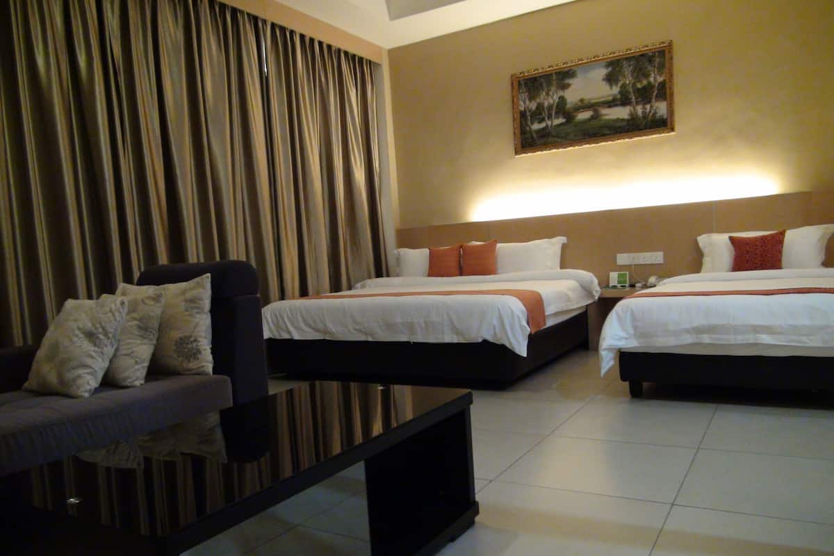 A hotel room with two beds, a sofa, a coffee table, and a painting on the wall.