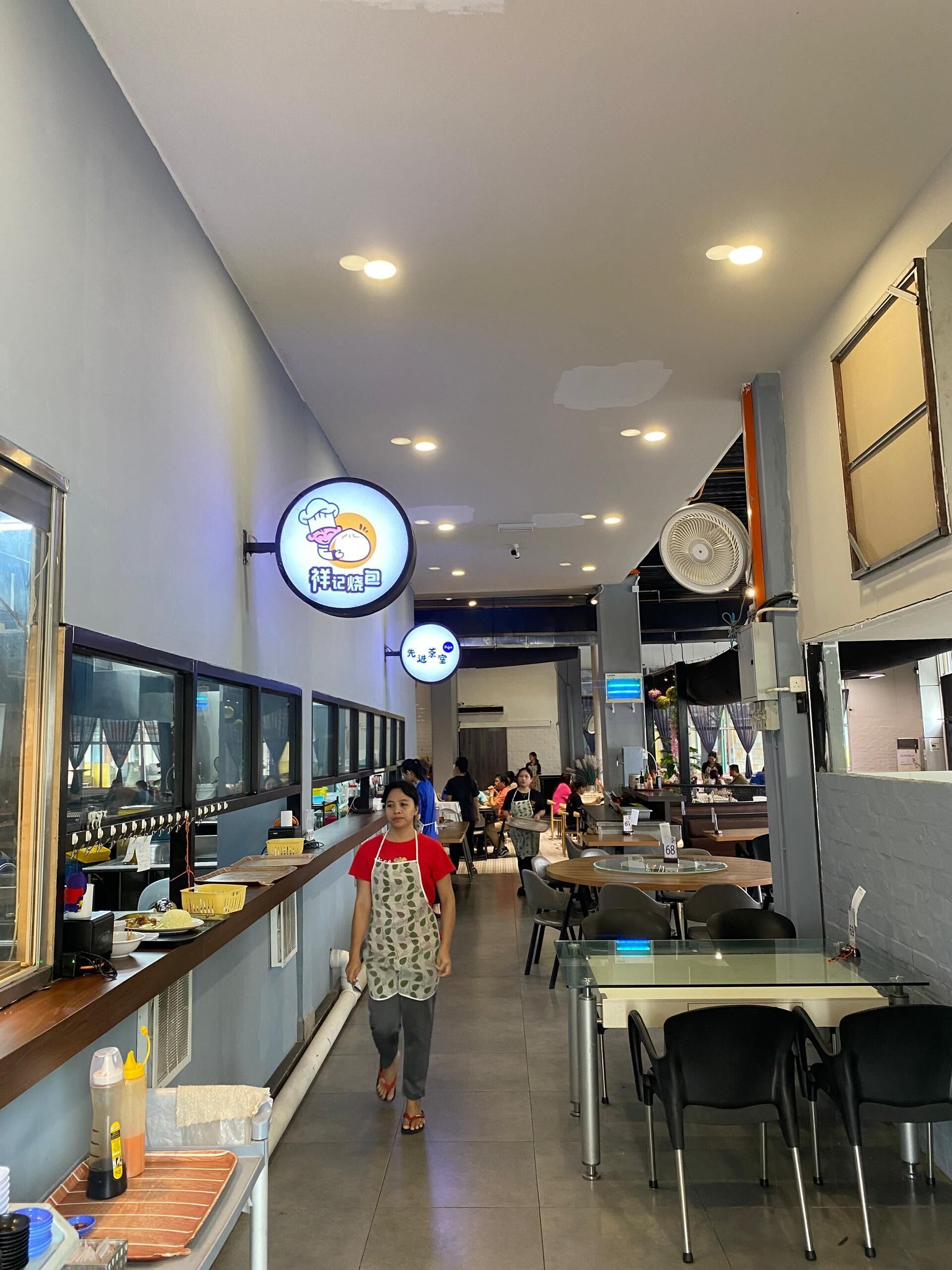 L'intérieur d'un restaurant avec un comptoir, des tables et des chaises.