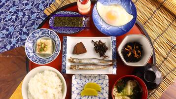 Un plateau contenant divers plats japonais, notamment du riz, du poisson et un bol de soupe.