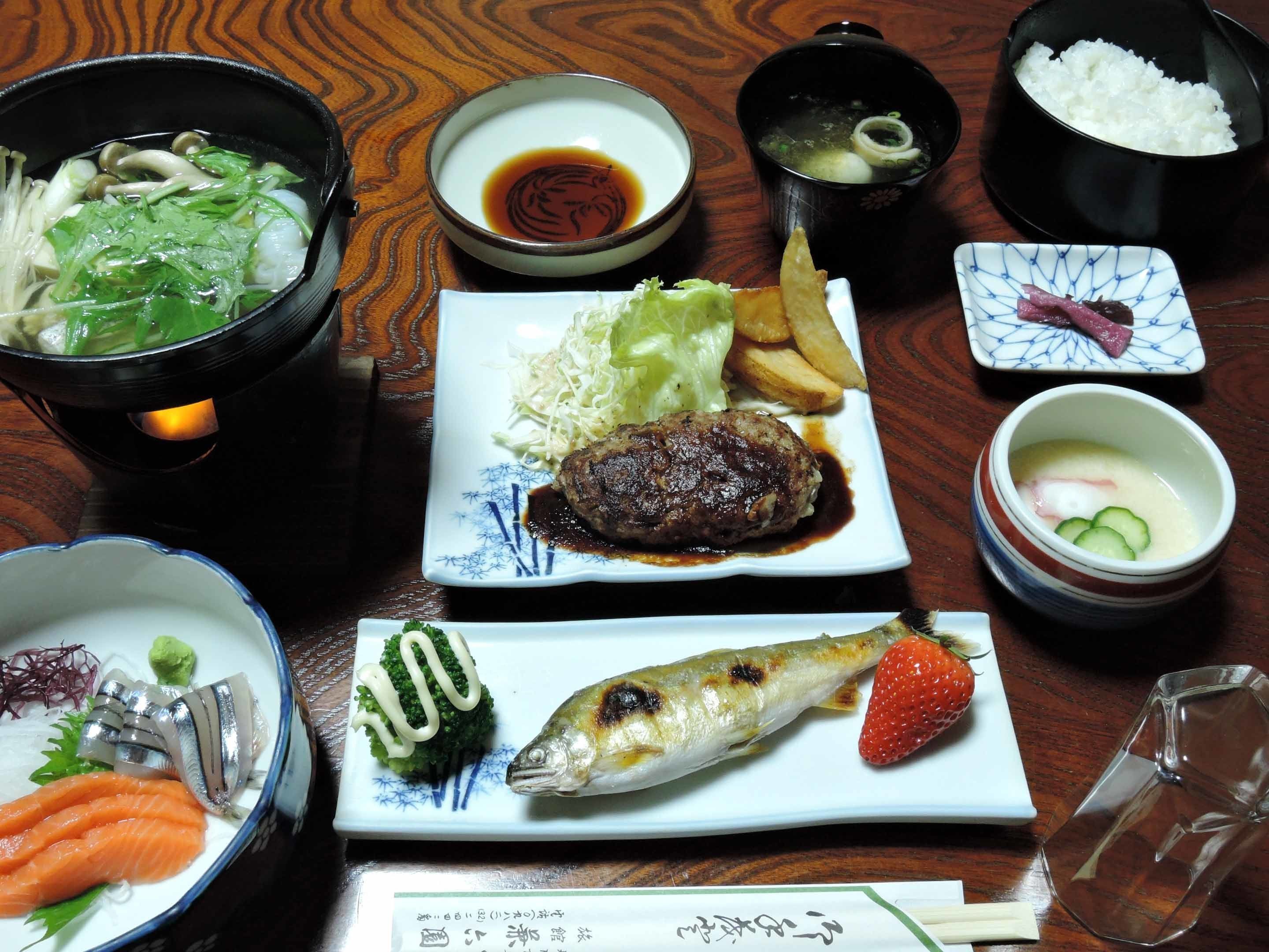 A variety of Japanese dishes including sushi, sashimi, and a bowl of soup.