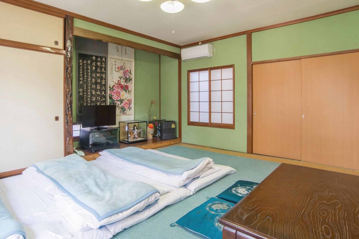 Une pièce de style japonais traditionnel, avec un sol recouvert de tatamis, une table basse et des portes coulissantes.