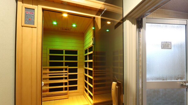 Un sauna avec des bancs en bois et une porte en verre.